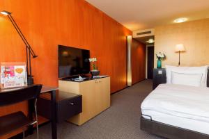 普费菲孔西德姆广场酒店的配有一张床和一张书桌的酒店客房