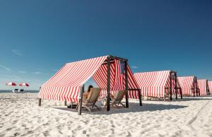 五月岬郡The Virginia and Cottages的海滩上一排红白的帐篷