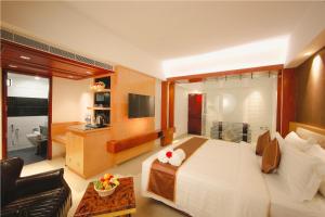 特里凡得琅Akhil Classic的一间带大床的卧室和一间客厅
