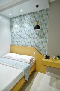 Daet达特福尔摩萨酒店的一间小卧室,配有一张床和一张书桌