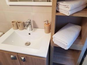 劳恩尼克Le Colombier Bretagne的一间带水槽和架子毛巾的浴室