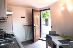 ZognoB&B San Pellegrino Terme的厨房设有一扇门,可通往带桌子的厨房
