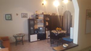 恩纳La collina delle ginestre的客厅配有桌子和电视