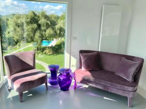 维罗纳Villa Il Bacio del Sole的带窗户的客房内配有两把椅子和一张沙发