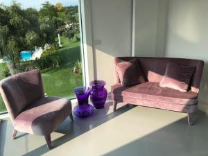 维罗纳Villa Il Bacio del Sole的带窗户的客房内配有两把椅子和一张沙发