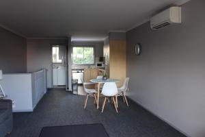 科夫斯港Aqualuna Apartments的配有桌椅和厨房的房间