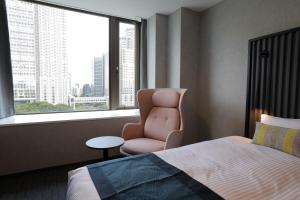 东京諾特 东京新宿的卧室配有床、椅子和窗户。
