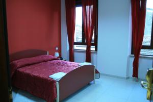 波波利阿尔伯格玛瑞旅馆 的一间卧室设有一张带红色墙壁和窗户的床。