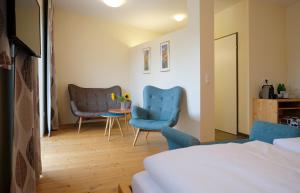 滨湖波德斯多夫纳赫特卡尔捷祖尔丹巴凯特民宿的一间卧室配有两张蓝色的椅子和一张桌子
