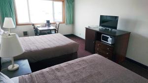 洛克威海滩银沙汽车旅馆的酒店客房设有两张床和一台平面电视。