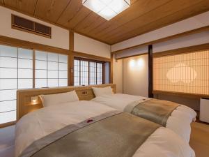 日田市乌梅奥下塔温泉旅馆的带窗户的客房内设有两张大床