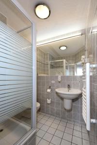 艾森许滕施塔特LAT Hotel & Apartmenthaus Berlin的一间带水槽、卫生间和淋浴的浴室