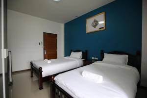 清莱SABUN-NGA HOSTEL的蓝色墙壁客房的两张床