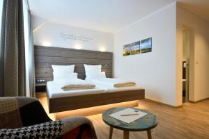 Fuhrbach德尔科龙普林兹酒店的一间卧室配有一张床、一把椅子和一张桌子
