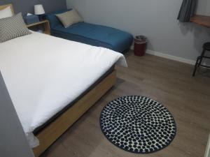 首尔哈哈旅馆的卧室配有一张床,地板上铺有地毯