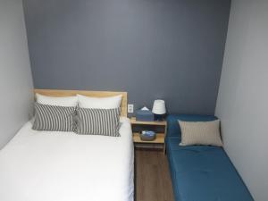 首尔哈哈旅馆的一间卧室配有一张床和一张蓝色的沙发