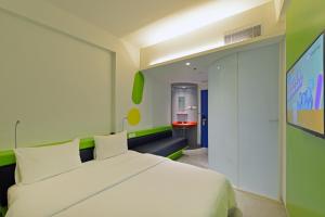 梭罗POP！索罗酒店的卧室配有白色的床和绿色的墙壁