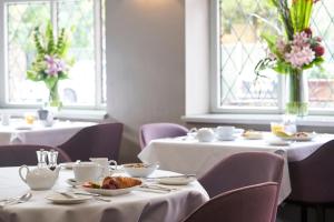 伦敦温布尔登安托瓦内特酒店的用餐室设有2张桌子和白色桌布,并可能令客人感到愤怒
