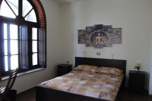 Settimo VittonePassaggio a Nord Ovest的一间卧室设有一张床和一个大窗户