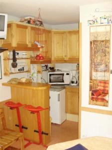 马尼戈MONT BLANC Soleil C19的厨房配有木制橱柜和炉灶烤箱。