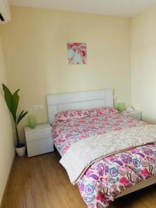 马拉加Flamingo Apartment的一间卧室配有一张床和盆栽植物