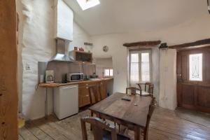 圣莱伊德苏La maison d'Angèle的厨房铺有木地板,配有木桌。