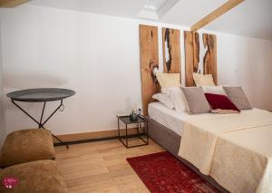 吉马良斯L'atelier Apartments (Fotografia)的一间卧室配有一张带木制床头板和一张桌子的床。