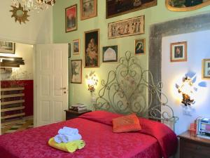 卡麦奥雷La Stagione dell'Arte的一间卧室配有红色的床和毛巾