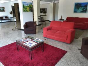 雷森迪Hotel Vila Rica Flat的客厅配有红色沙发和咖啡桌