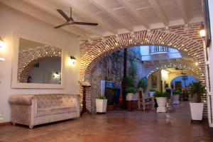 卡塔赫纳Casa Villa Colonial By Akel Hotels的一个带沙发和砖墙的大堂