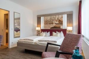 诺尔登堤岸布赫霍尔茨弗罗曼斯乡村酒店的一间卧室配有一张壁画床