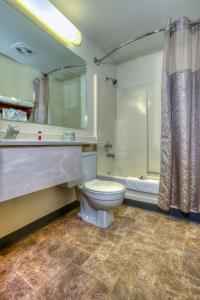 杰克逊杰克逊霍尔速8汽车旅馆的浴室配有卫生间、淋浴和浴缸。