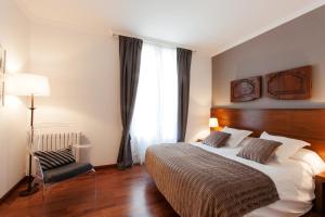 巴塞罗那西里尼亚兰布拉加泰罗尼亚广场酒店的卧室配有床、椅子和窗户。