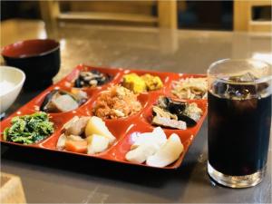 轻井泽轻井泽佐藤奴库利旅馆的酒杯旁的餐桌上的食物