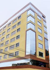 科恰班巴Apart Hotel Selenza的一座高大的黄色建筑,有很多窗户