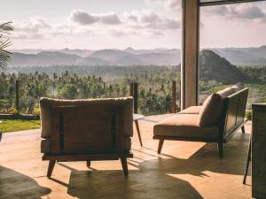 龙目岛库塔Villa Strata的客厅配有两把椅子,享有山景