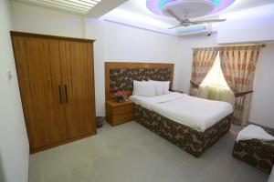 达卡纳加谷酒店的一间卧室配有床、橱柜和窗户