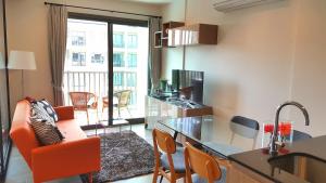 七岩七岩欧泊赛特飘雨公寓的一个带橙色椅子的客厅和一个厨房