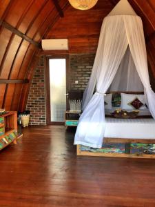 金巴兰Balangan海景简易别墅的一间卧室配有一张带蚊帐的床
