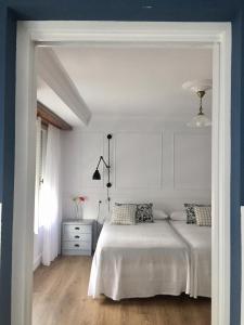 埃斯帕桑特港Las Palomas的白色的卧室设有床和窗户