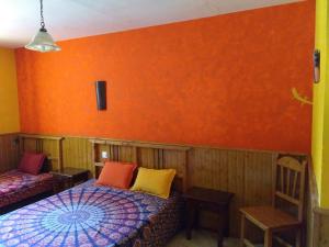 阿雷纳斯德圣佩德罗Casa Rural Las Gesillas的一间设有两张床和橙色墙壁的客房
