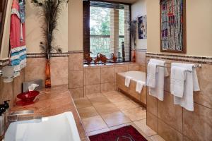 克卢夫艾玛祖鲁非洲宫酒店的带浴缸和盥洗盆的浴室
