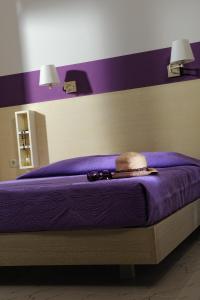 赫索尼索斯达娜厄别墅酒店的紫色的床,上面有帽子和太阳镜