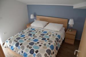 波尔托罗Apartments Ostanek 2的一间卧室配有一张带蓝色和白色棉被的床