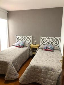 阿里纳加Apartamento playa arinaga的一间卧室设有两张床和窗户。