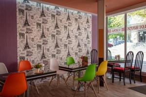 瓦尔纳Family Hotel Varna的餐厅配有五颜六色的椅子和一张带窗帘的桌子