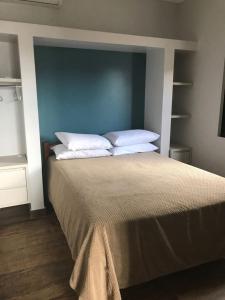 帕罗卡Residencial Sol e Lua的一间卧室配有一张带蓝色床头板和白色枕头的床。