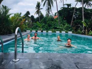 MoragallaSath Villa Naadi Ayurveda Resort的一群人在游泳池游泳