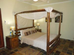 科玛蒂普特特瑞斯图旅馆的卧室配有带白色床单的木制天蓬床