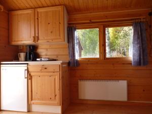 Hammarstrand4 persoons Stuga的厨房配有木制橱柜和窗户。